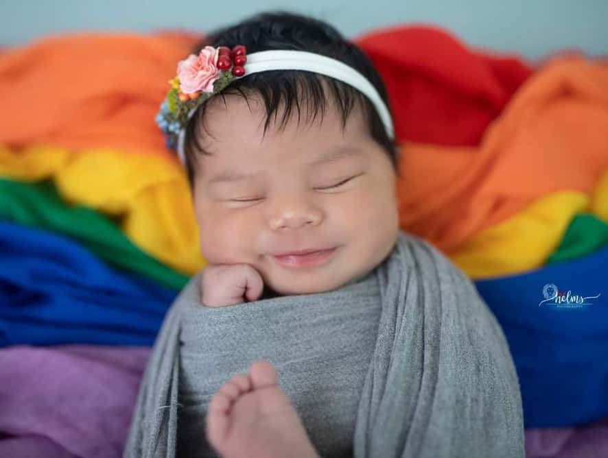 baby wrapped in rainbow blanket - testimonial for Larua L.